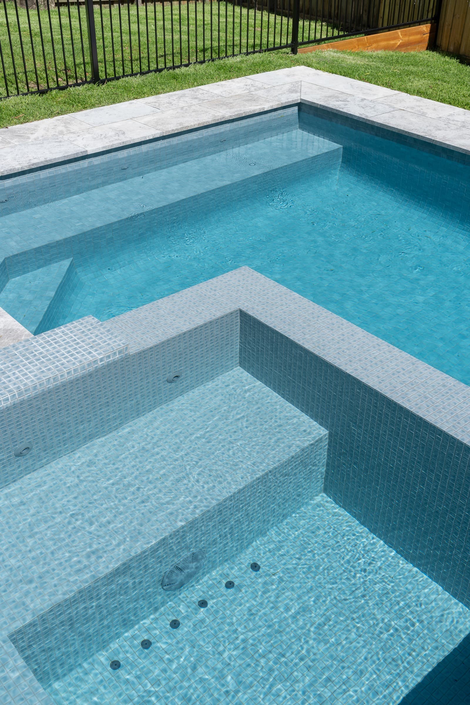Detailed finish around a raised spa and adjoining completed concrete pool