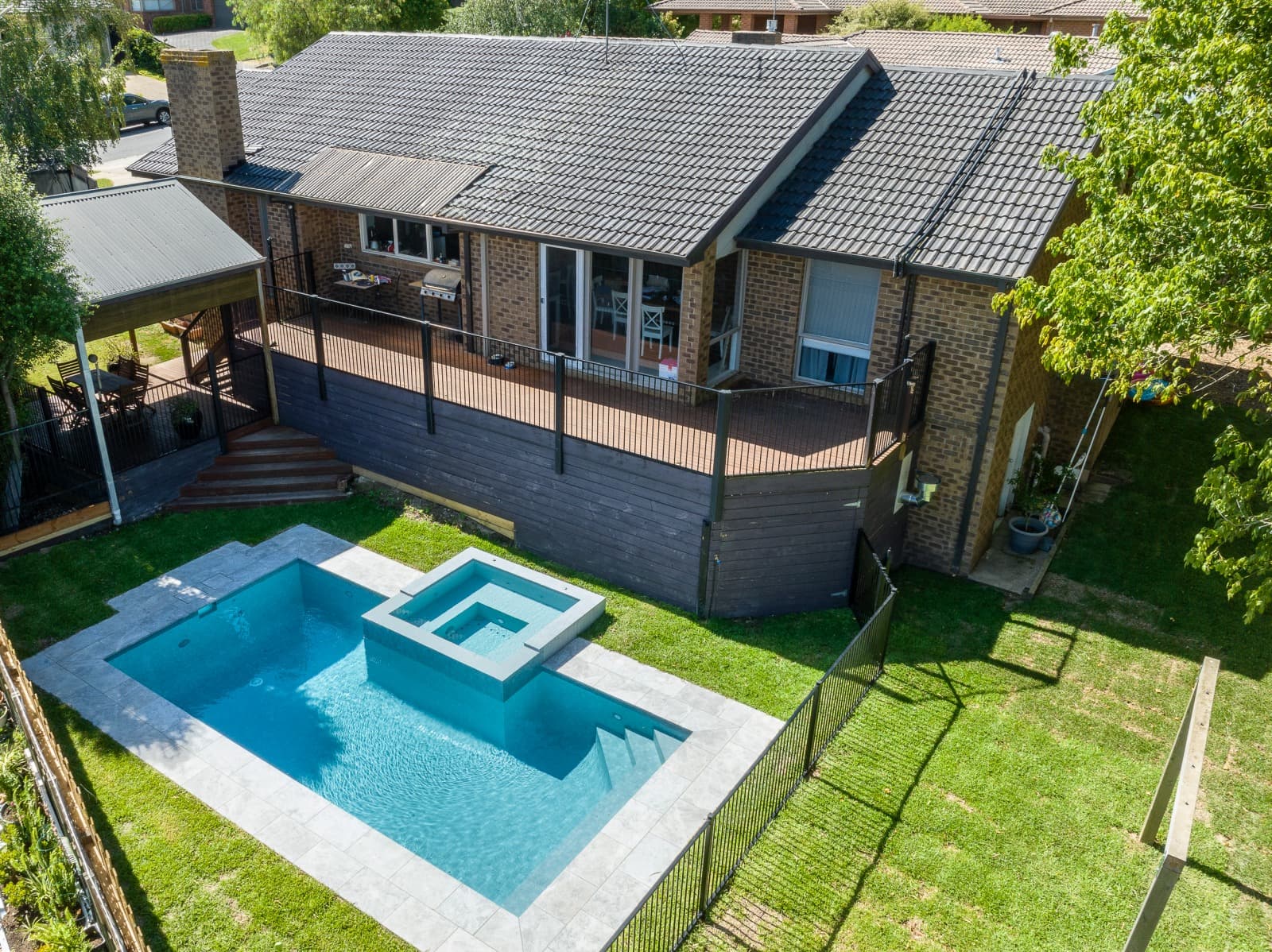 Aerial view of a completed Enchanted concrete pool and raised spa beside a Melbourne home