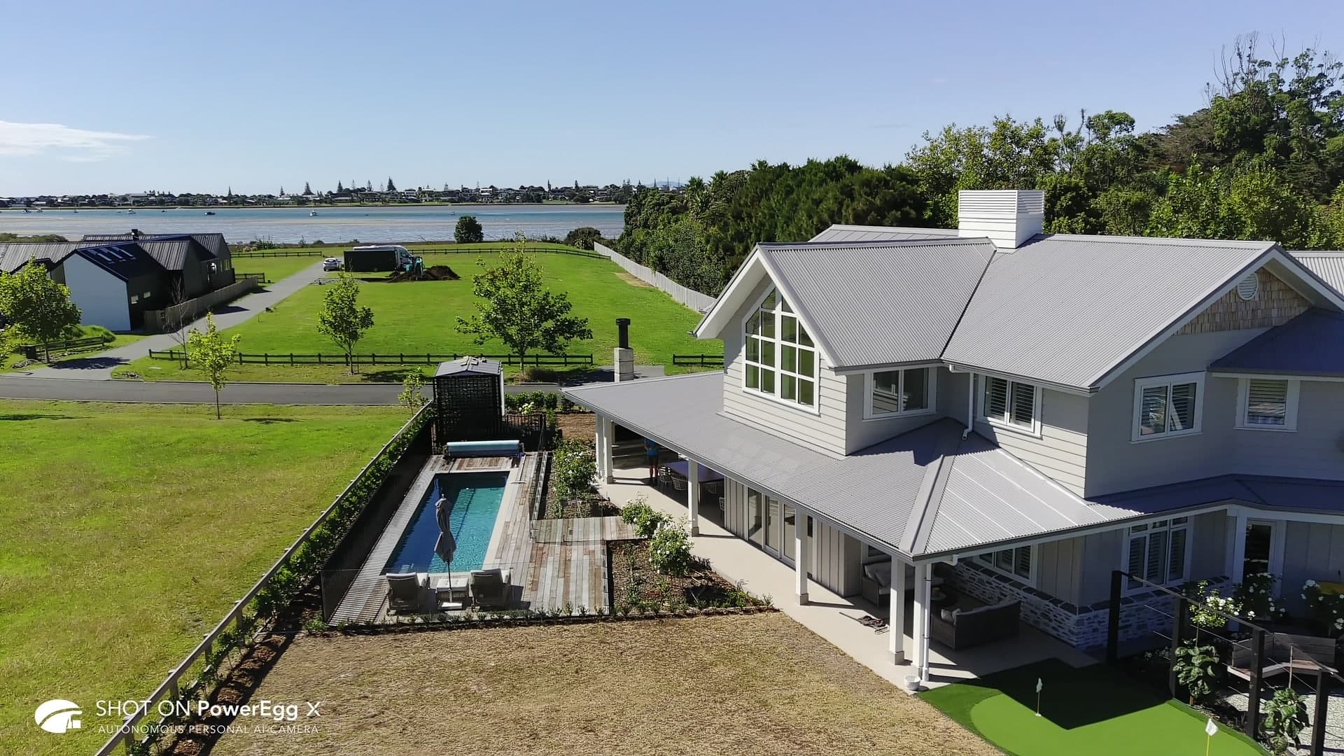 Aerial view of a Fastlane lap pool beside a grey country home