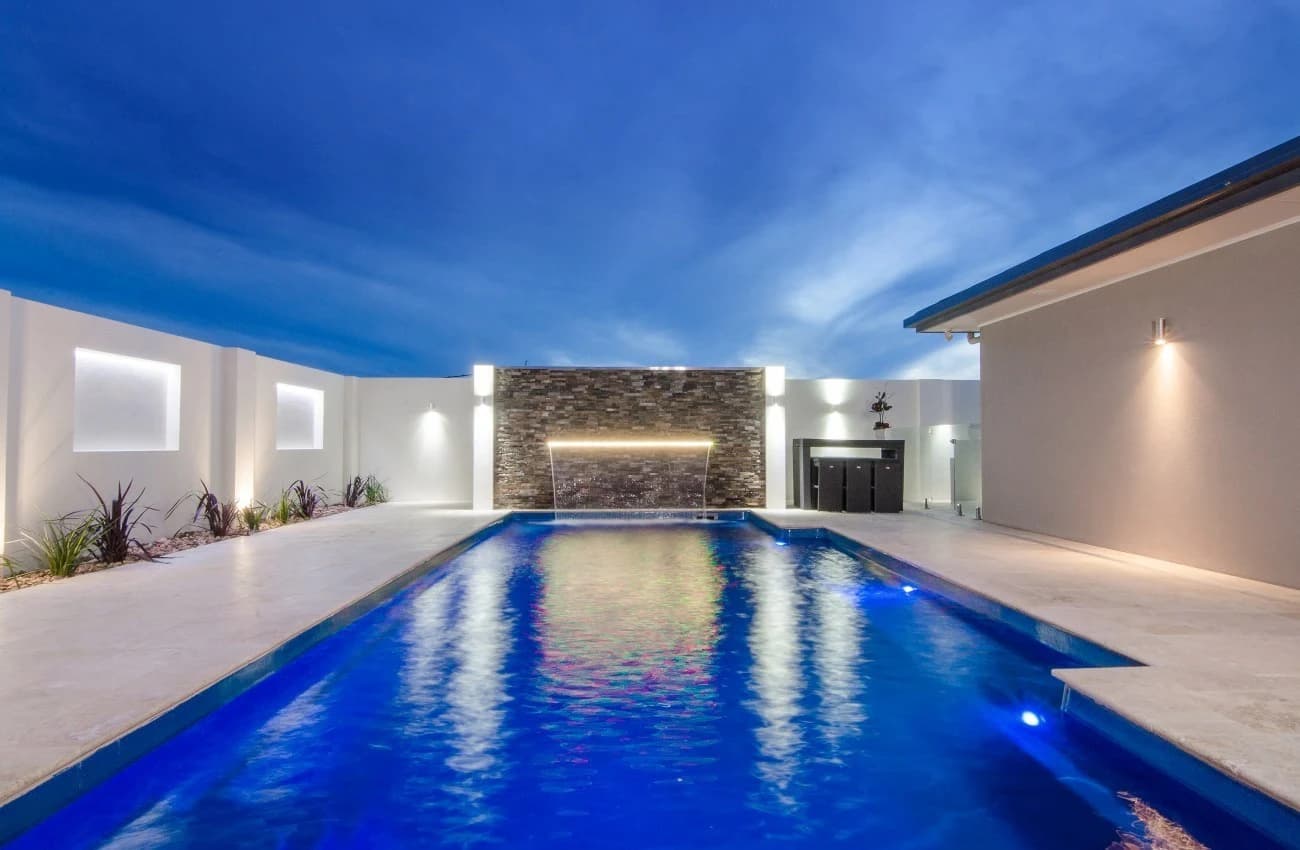 Compass fibreglass pool with integrated lighting and a raised water feature