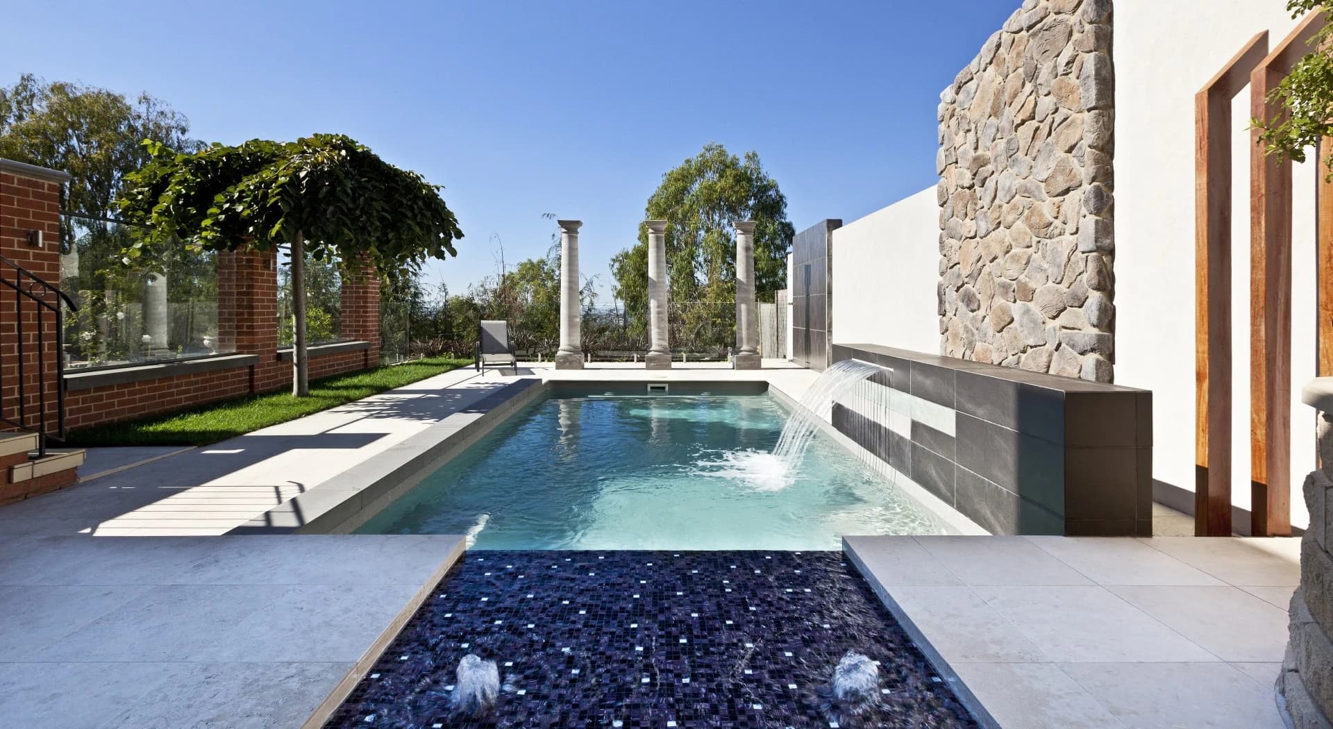 Compass fibreglass pool with a raised Sunpod water feature