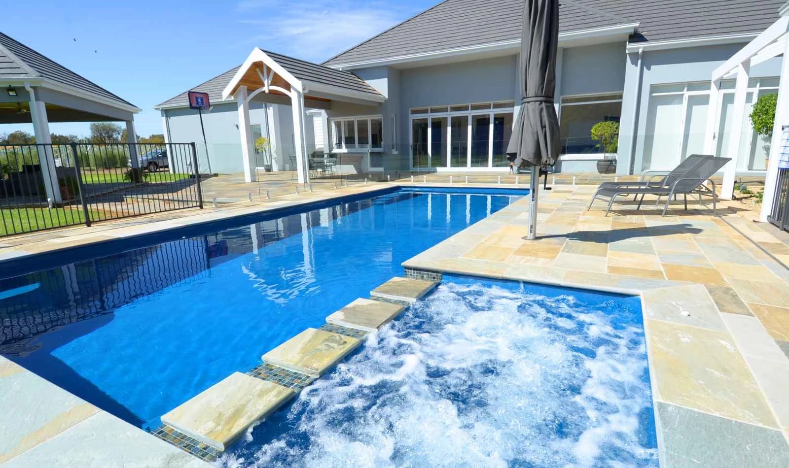 Compass fibreglass pool and spa combination in a residential backyard