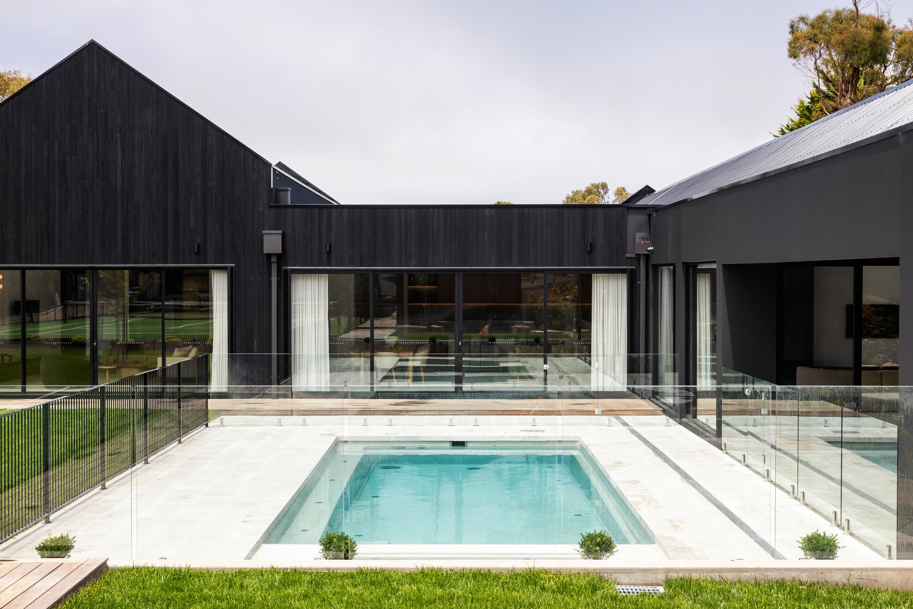 Sanctuary fibreglass pool framed by a black contemporary home