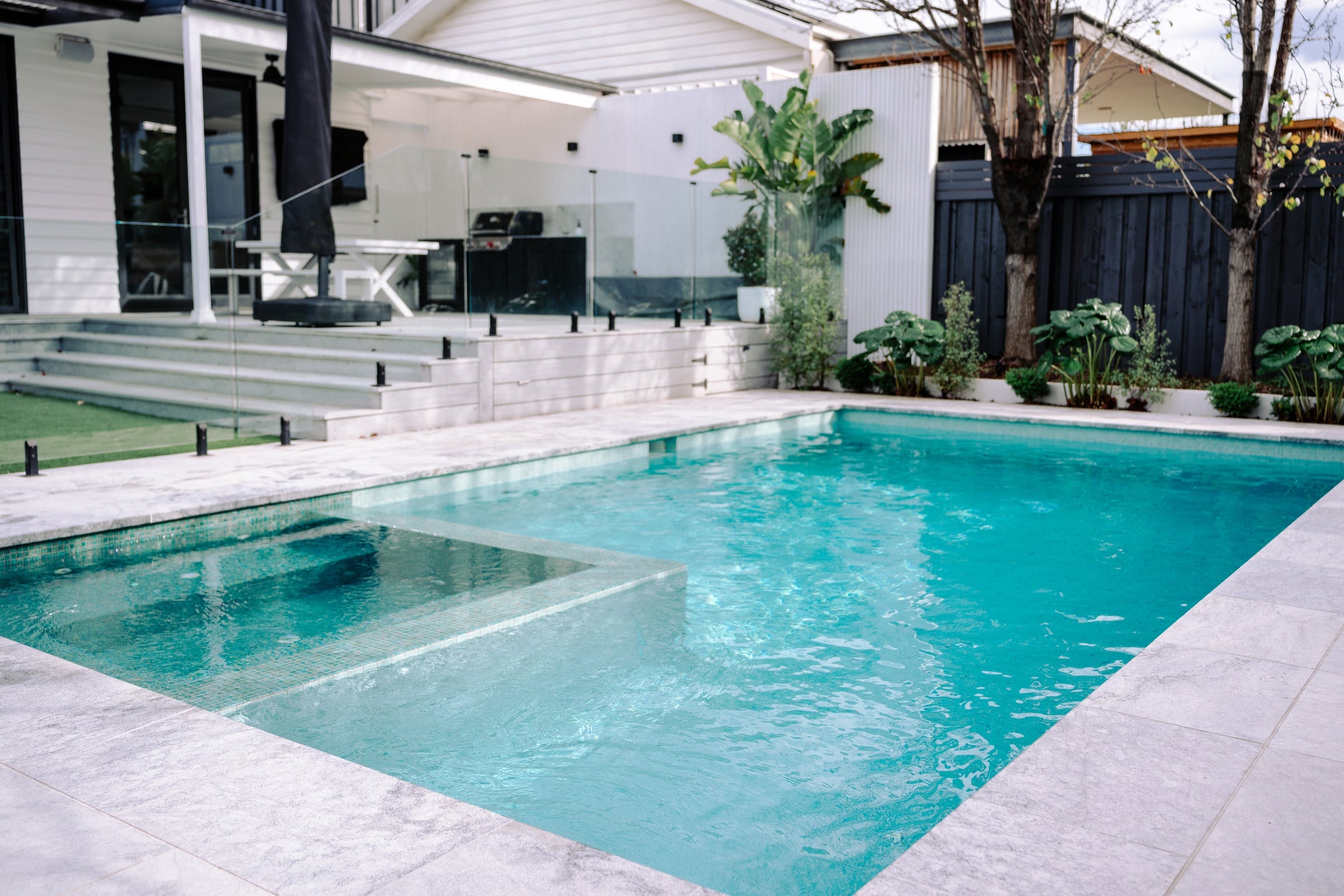 Fully tiled pool and integrated glass mosaic spa looking towards the home's entertaining deck
