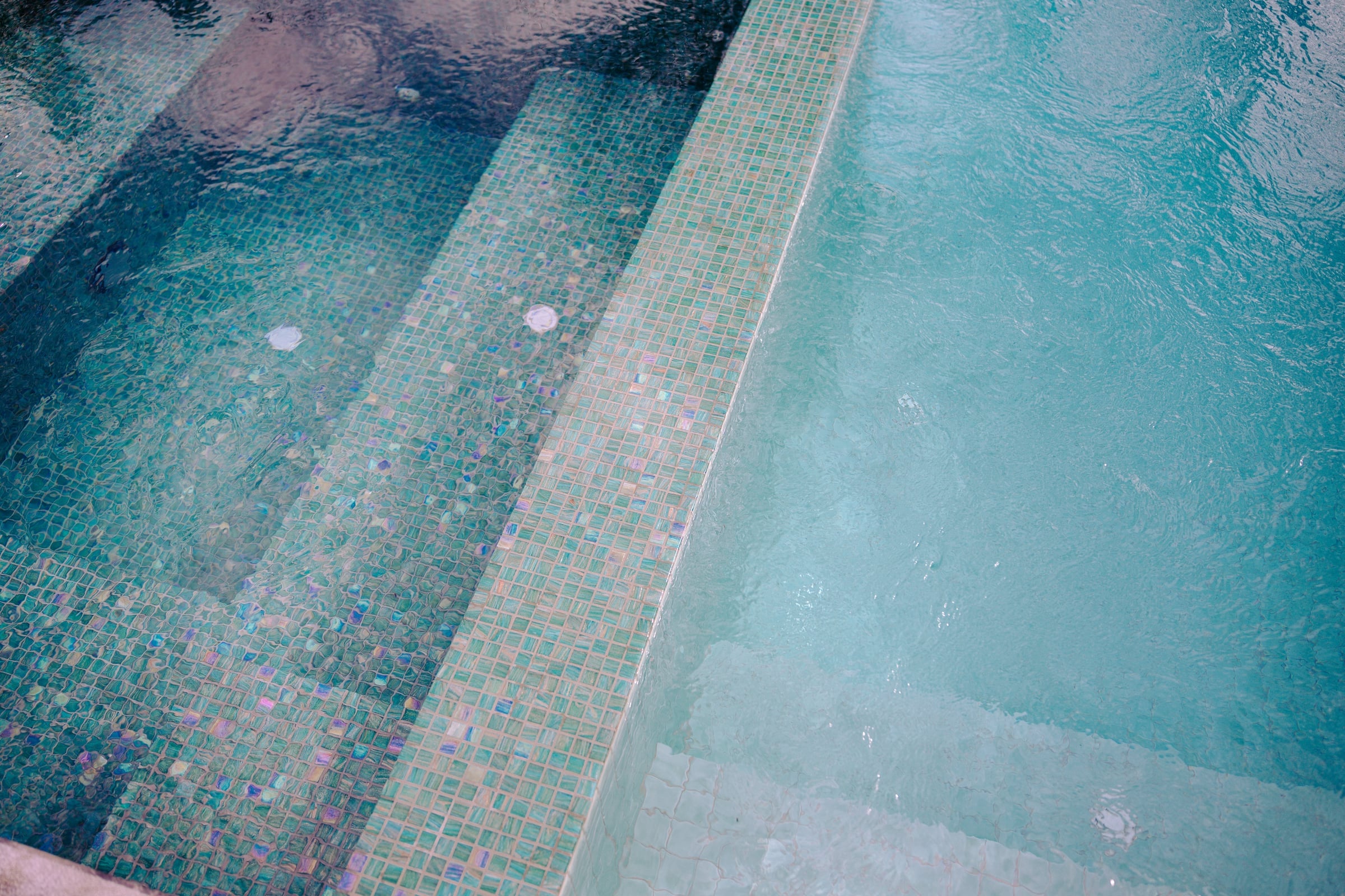 Lorikeet glass mosaic tiles and bubbling water at the edge of the integrated spa