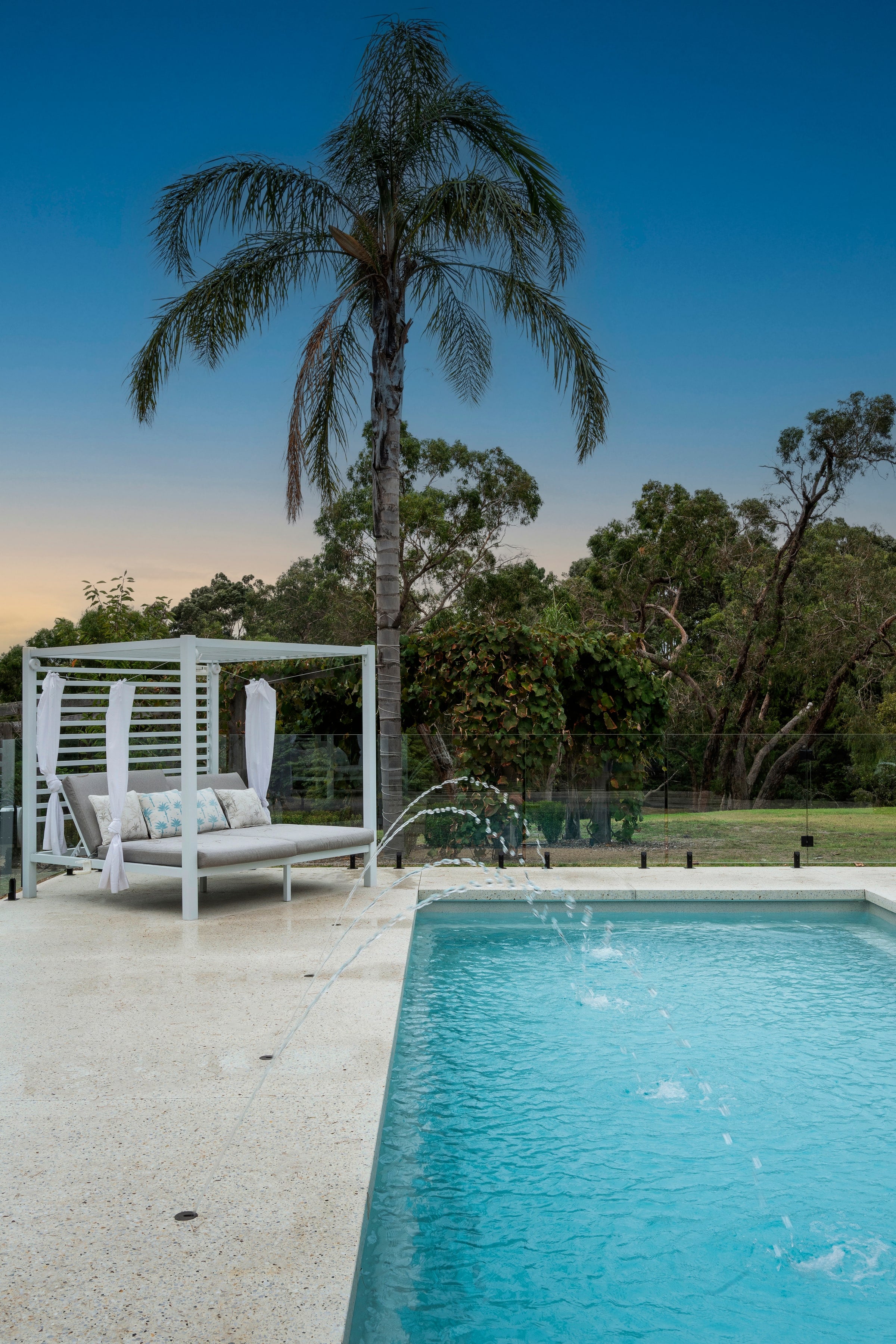 Palm, day bed and fountain jets beside the pool in Pearcedale